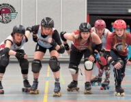 Five fierce looking roller derby players reday to sprint into action